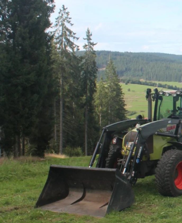 Traktor mit Frontlader auf einer Wiese bei Vöhrenbach